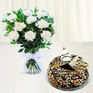 10 white carnations arranged in glass vase with dry fruit cake 