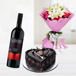 Bunch of red carnation with white lilies with heart shape chocolate truffle cake with bottle of red wine