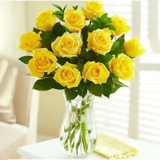 12 yellow roses arranged in glass vase 