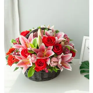 Basket arrangement of 10 red roses with 3 pink lilies