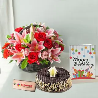Basket Arrangement of mix exotic flowers with half kg chocolate almond cake with birthday card 