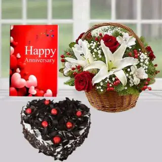 Basket arrangement of red and white lilies , heart shape black forest cake, anniversary  greeting card 