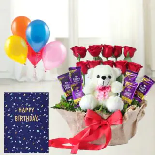 Basket arrangement of 10 roses with 6 dairymilk , with 6 inch teddybear sitting in it, birthday greeting card with 5 blown balloons 