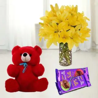 6 yellow lilies in glass vase with 6 inch red teddybear with set of 2 dairy milk chocolates