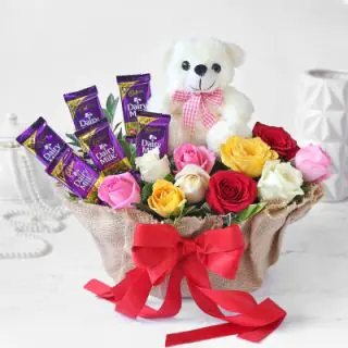BEautiful Basket arrangement of 10 mix roses, 6 dairy milk chocolates, with 6 inch teddybear sitting in it 