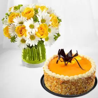 Beautiful vase arrangement of white gerberas, yellow roses with mango cool cake