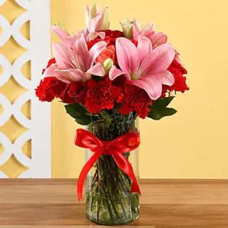 Vase arrangement of 10 red carnations with 2 pink lilies 