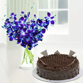 Vase arrangement of blue orchids with chocolate cake 