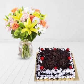 vase arrangement of lilies, roses and daisies, with black forest cake