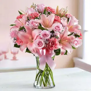 Vase arrangement of pink carnations , pink roses with pink lilies 