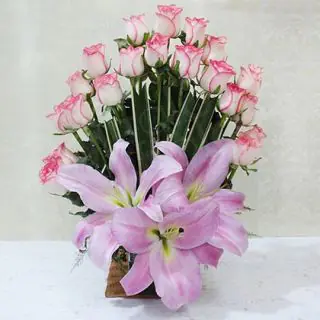Basket arrangement of pink roses with pink lilies
