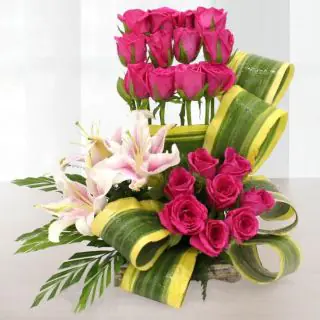 Basket arrangement of red roses with pink lilies