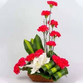 basket arrangement of red carnations with white lilies