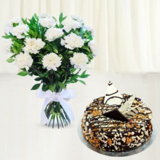 10 white carnations arranged in glass vase with dry fruit cake 
