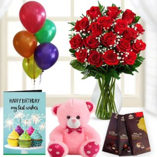 15 red roses in glass vase, 3 bournville dark chocolates,6 inch pink teddybear, birthday Greeting card with 5 blown balloons 