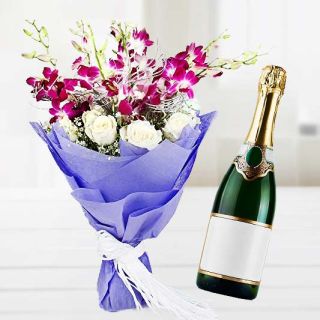 Bunch of lavender orchids with white roses with bottle of champegne