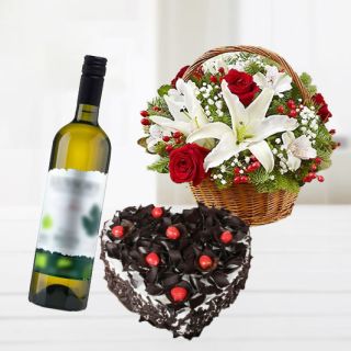 Basket arrangement of lilies with roses with heart shape chocolate truffle cake with bottle of white wine