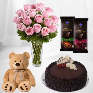 12 pink roses in glass vase with 1 feet height brown teddybear with chocolate chips cake with pair of 2 bournville dark chocolates 