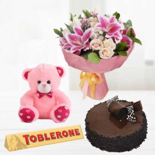 Bunch of exotic mix flowers with 6 inch pink teddybear with toblerone chocolates with chocolate truffle cake 