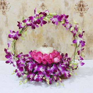 Basket arrangement of 10 purple orchids with 10 pink 5 white roses 
