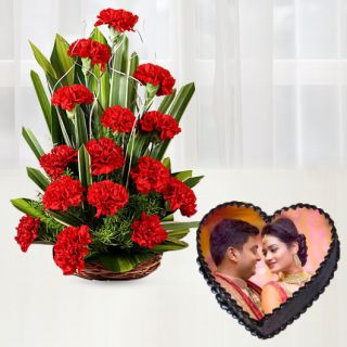 Basket arrangement of 20 red carnations with heart shape chocolate photo cake 