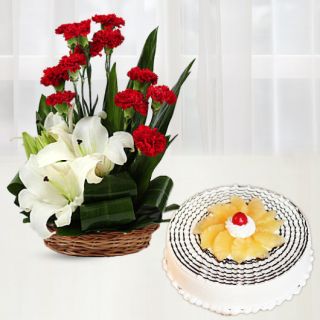 Basket arrangement of 2 white lilies with 10 red carnation with pineapple cool cake 
