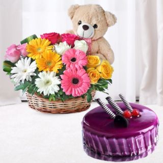 Basket arrangement of mix color gerberas roses with teddy bear sitting in it, black currant cool cake 