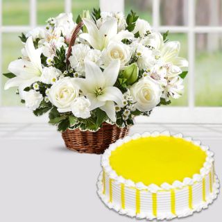 Basket arrangement of white lilies with white carnations with pineapple cake 