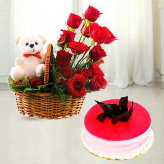 Basket of 10 red roses with teddy bear sitting in it with strawberry cake 