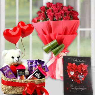 Basket of assorted chocolates with teddybear sitting in it, bunch of 12 15 red roses, valentine day greeting card, pair of heart shape balloons 