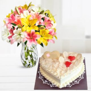 Beautiful mix lilies vase arrangement with heart shape white forest cake 
