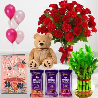 Beautiful vase arrangement of 20 red roses with carnations, set of 3 dairy milk silk chocolates, 6 inch height teddybear , 2 layer Lucky bamboo plant ,5 blown balloons with birthday greeting card