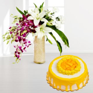 Beautiful vase arrangement of purple orchids with white lilies with mango cool cake