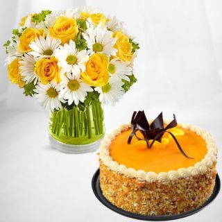 Beautiful vase arrangement of white gerberas, yellow roses with mango cool cake