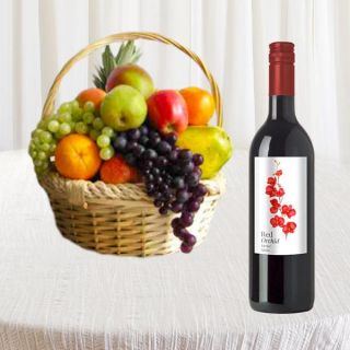 Bottle of red wine with basket of assorted fruits 