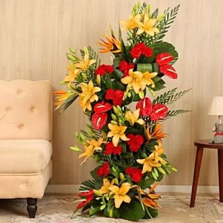 Exclusive 4 feet height Exotic arrangement of Asiatic orange lilies with red carnations and Red anthuriums 