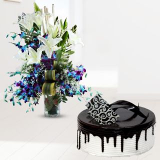 Exclusive vase arrangement of blue orchids with white lilies with choco vanilla cool cake 