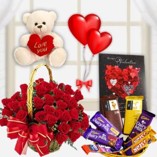Lovely Surprise --Basket Arrangement of 40 red roses with basket of assorted chocolates, 1 feet height white teddybear ,greeting card with pair of 2 heart shape balloons 