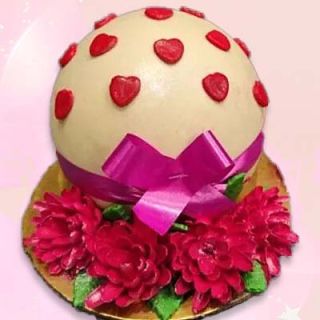 Vanilla pinata cake with red heart fondant topping 