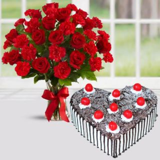 Vase arrangement of 20 red roses and red carnations with heart shape black forest cake 