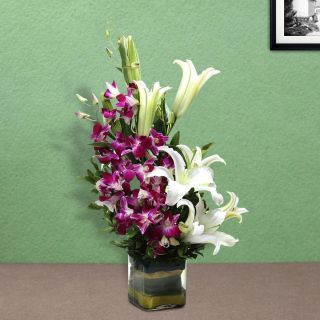 Vase Arrangement of 5 purple orchids with 3 white lilies 
