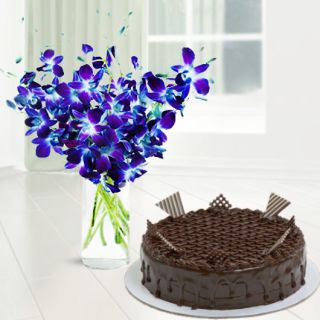 Vase arrangement of blue orchids with chocolate cake 