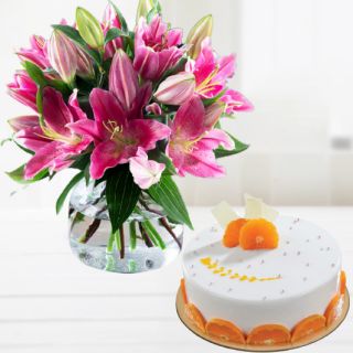 Vase arrangement of pink lilies with orange cool cake 