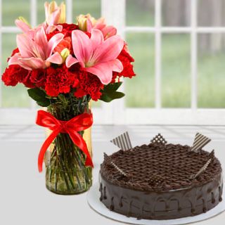 Vase arrangement of pink lilies with red roses with chocolate cakes