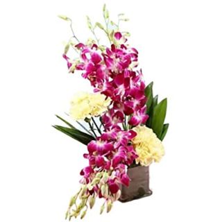 Vase arrangement of yellow carnations with purple orchids 