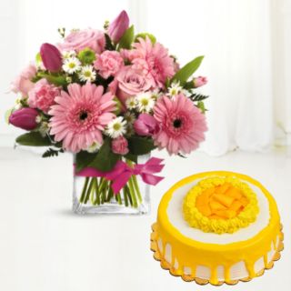 Vase arrangment of pink gerberas with mango cool cake 