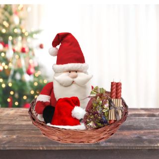 Box Of Chocolates With Santa Clause Toys, Santa Cap, And Candles Arranged In A Basket 